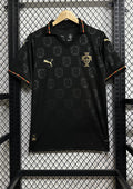 Portugal (Concept / Lifestyle) Noir, motifs répétitifs de l'emblème national en ton sur ton, col polo avec liseré vert et rouge, logos Puma et écusson en doré. GoalKits