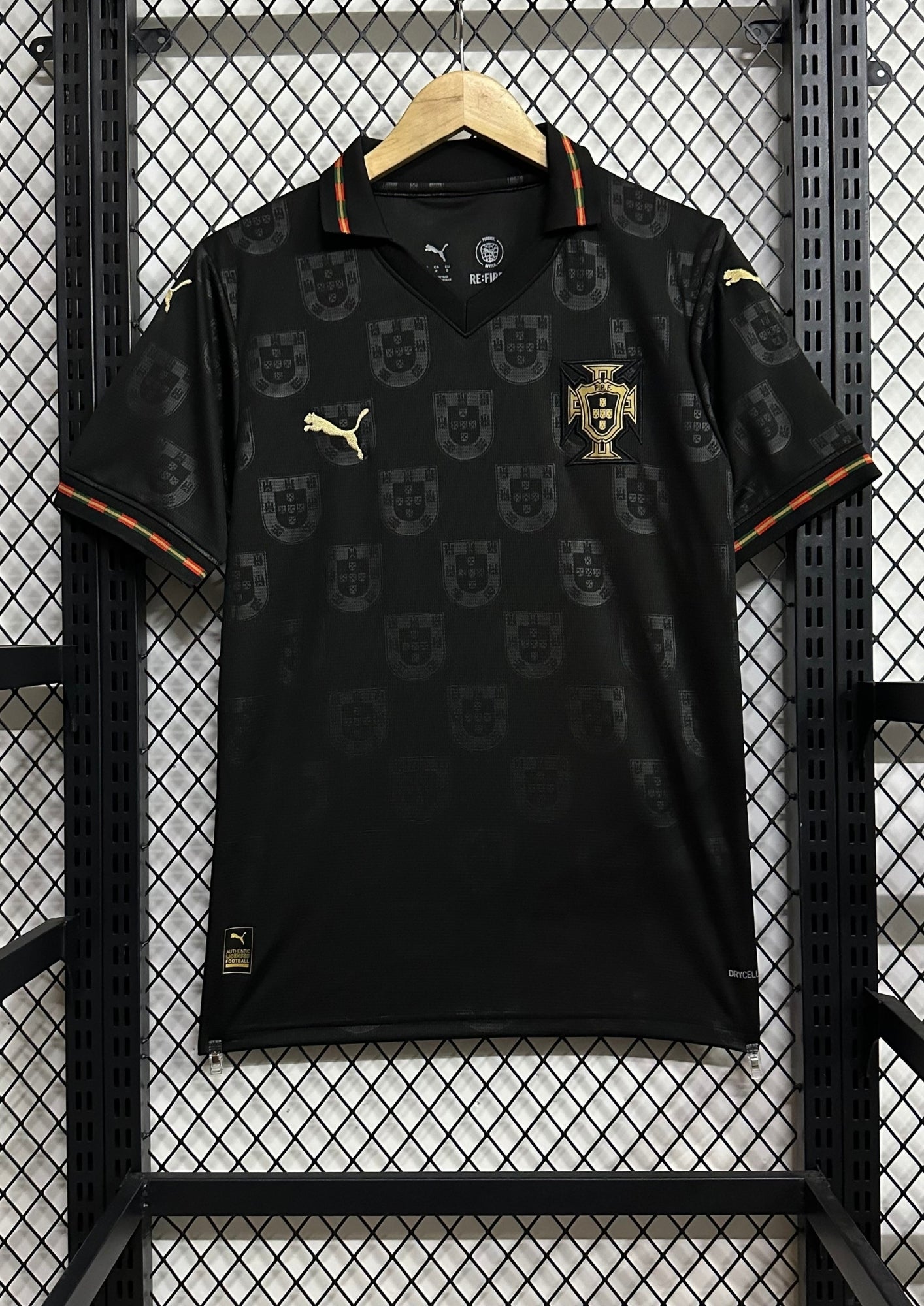Portugal (Concept / Lifestyle) Noir, motifs répétitifs de l'emblème national en ton sur ton, col polo avec liseré vert et rouge, logos Puma et écusson en doré. GoalKits