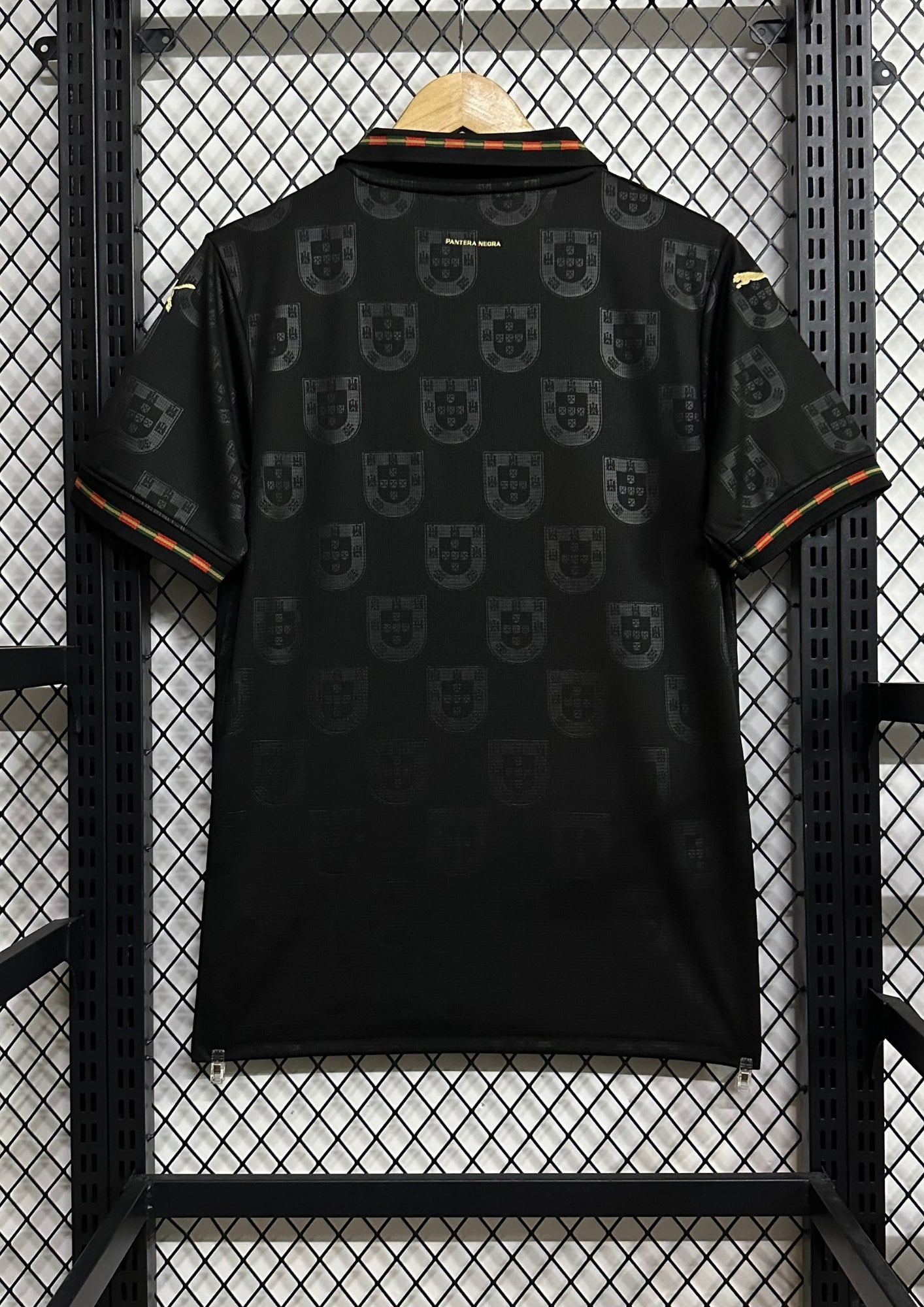 Portugal (Concept / Lifestyle) Noir, motifs répétitifs de l'emblème national en ton sur ton, col polo avec liseré vert et rouge, logos Puma et écusson en doré. GoalKits