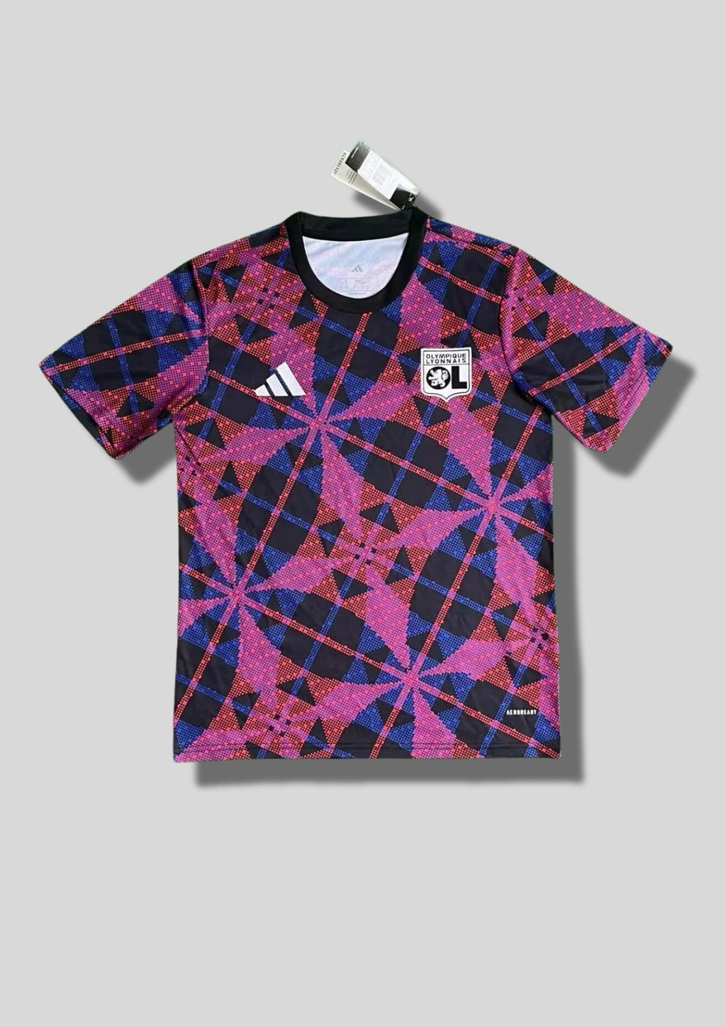 Olympique Lyonnais "Pre-match" géométrique : maillot noir orné d'un motif complexe de croix et de losanges formés par des pointillés roses et bleus, logo Adidas blanc et blason OL monochrome. GoalKits