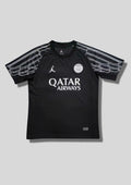 Paris Saint-Germain Jordan noir & "ailes" argentées : maillot Fourth d'entraînement noir avec des motifs graphiques stylisés en forme d'ailes argentées sur les manches, logos blancs et sponsor Qatar Airways. GoalKits