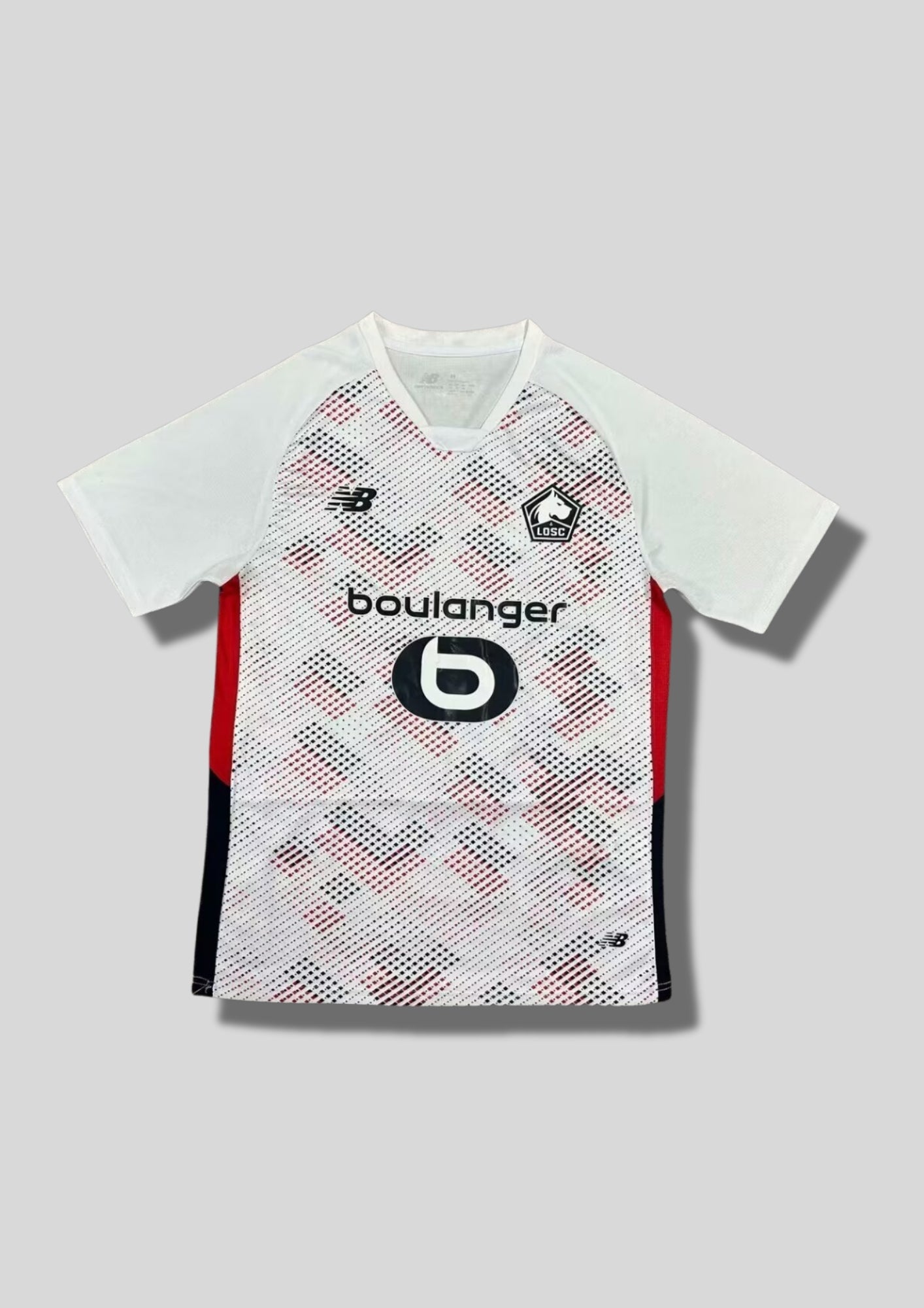 LOSC Lille extérieur 2023-2024 : maillot blanc avec un motif graphique de points rouges et bleu marine formant des diagonales sur le torse, flancs bicolores rouge et noir, logos noirs et sponsor Boulanger. GoalKits
