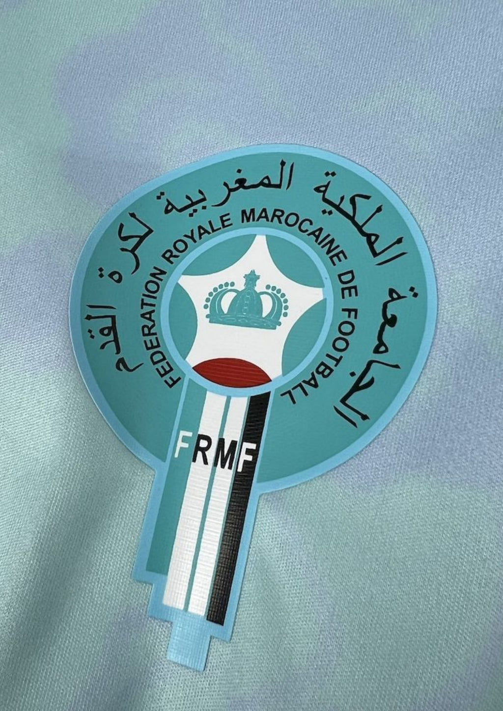 Maroc (Aqua) Dégradé bleu ciel et bleu roi, motifs de nuages et chevaux, logos Puma et FRMF. GoalKits