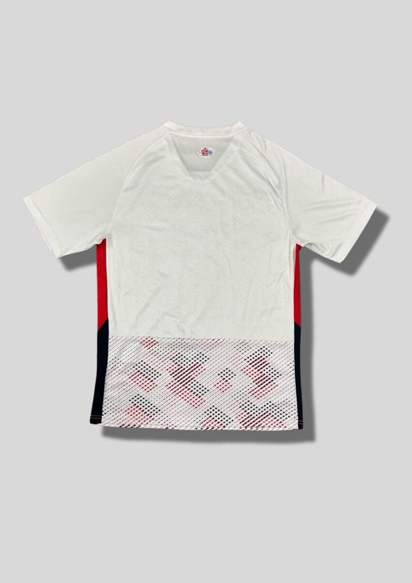 LOSC Lille extérieur 2023-2024 : maillot blanc avec un motif graphique de points rouges et bleu marine formant des diagonales sur le torse, flancs bicolores rouge et noir, logos noirs et sponsor Boulanger. GoalKits