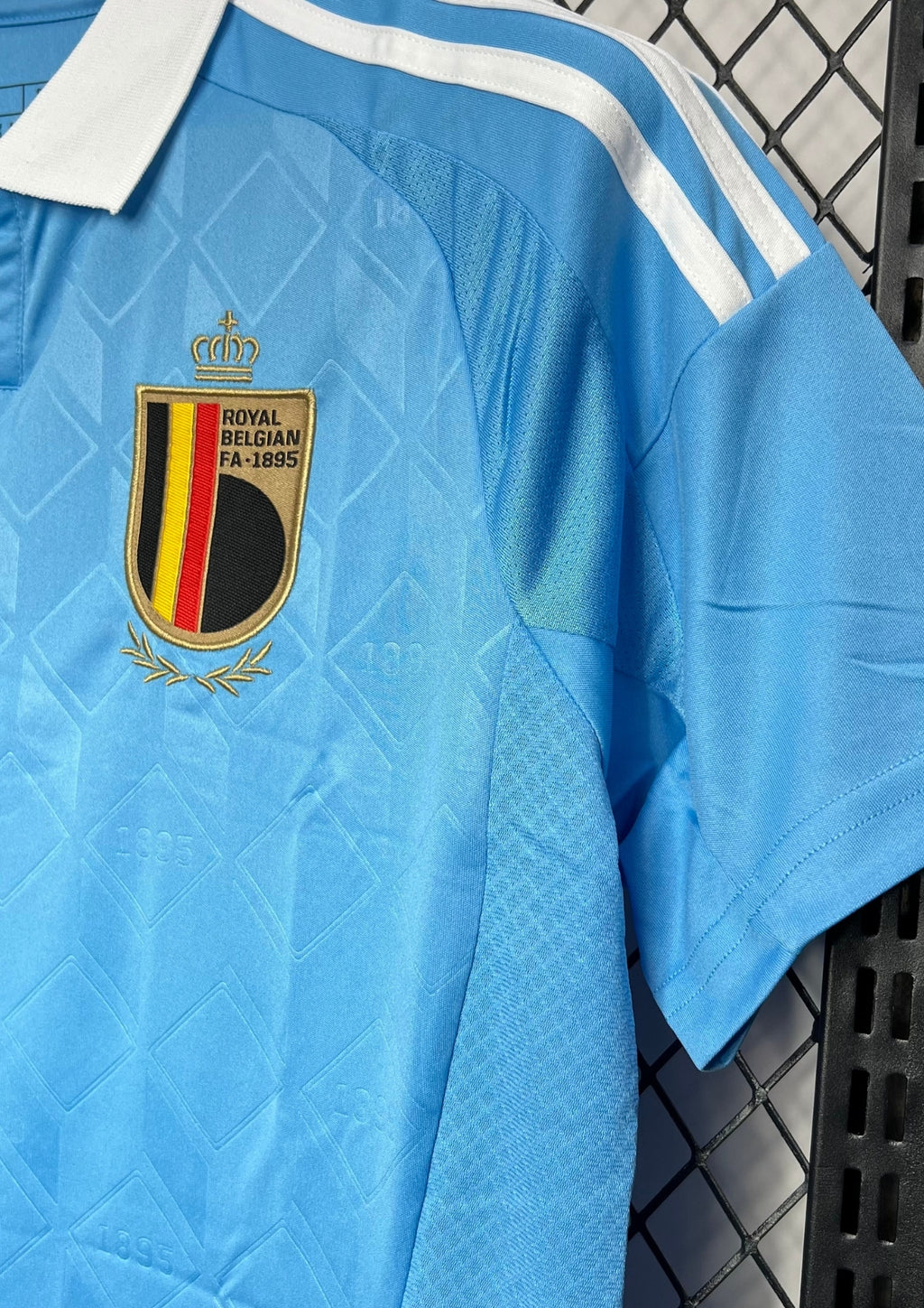 Belgique (Tintin) Bleu ciel avec col blanc, motifs géométriques ton sur ton incluant l'année "1895", logos Adidas doré et RBFA. GoalKits