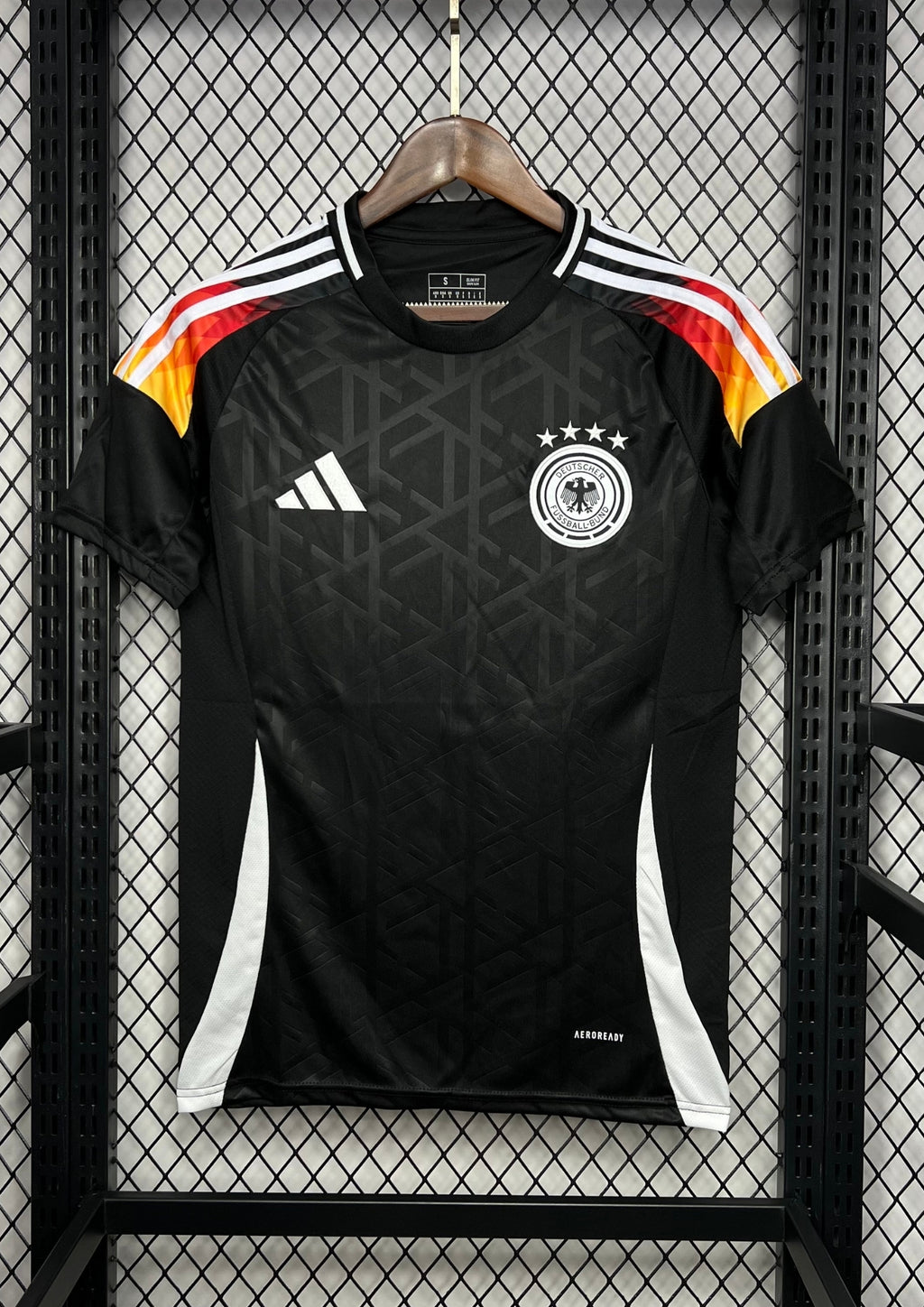 Allemagne (Édition Noir & Feu) Noir avec dégradé tricolore sur les épaules, motifs géométriques ton sur ton, logos Adidas et DFB blancs. GoalKits