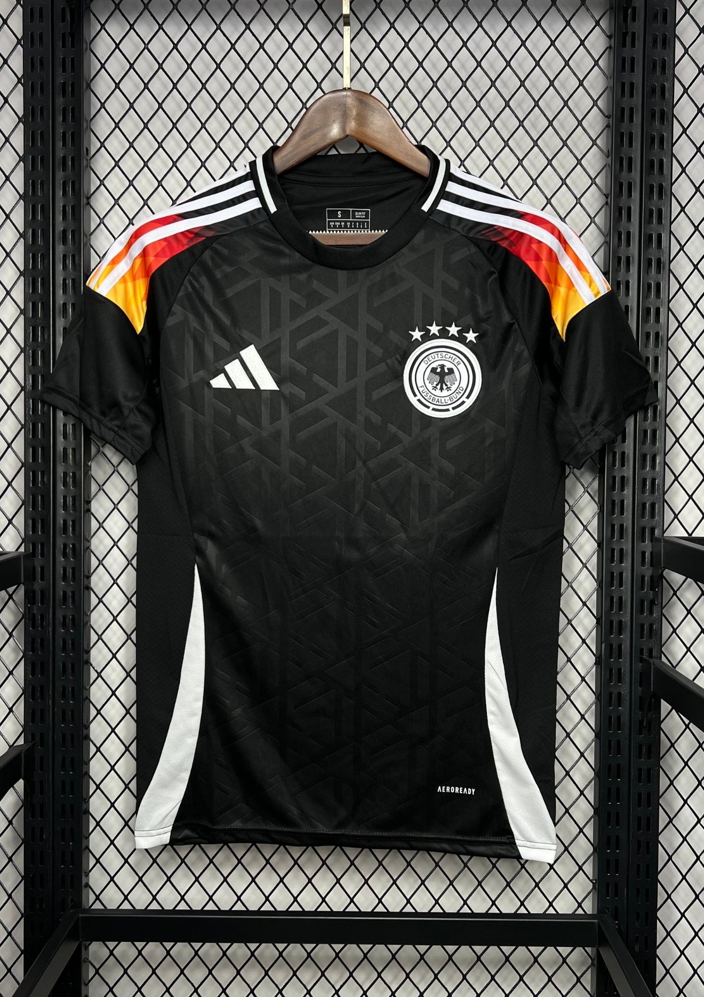 Allemagne (Édition Noir & Feu) Noir avec dégradé tricolore sur les épaules, motifs géométriques ton sur ton, logos Adidas et DFB blancs. GoalKits