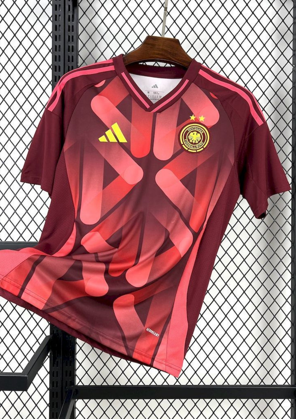 Allemagne (Bordeaux Edition) Bordeaux, motifs abstraits rose vif, logos Adidas et DFB jaune néon. GoalKits