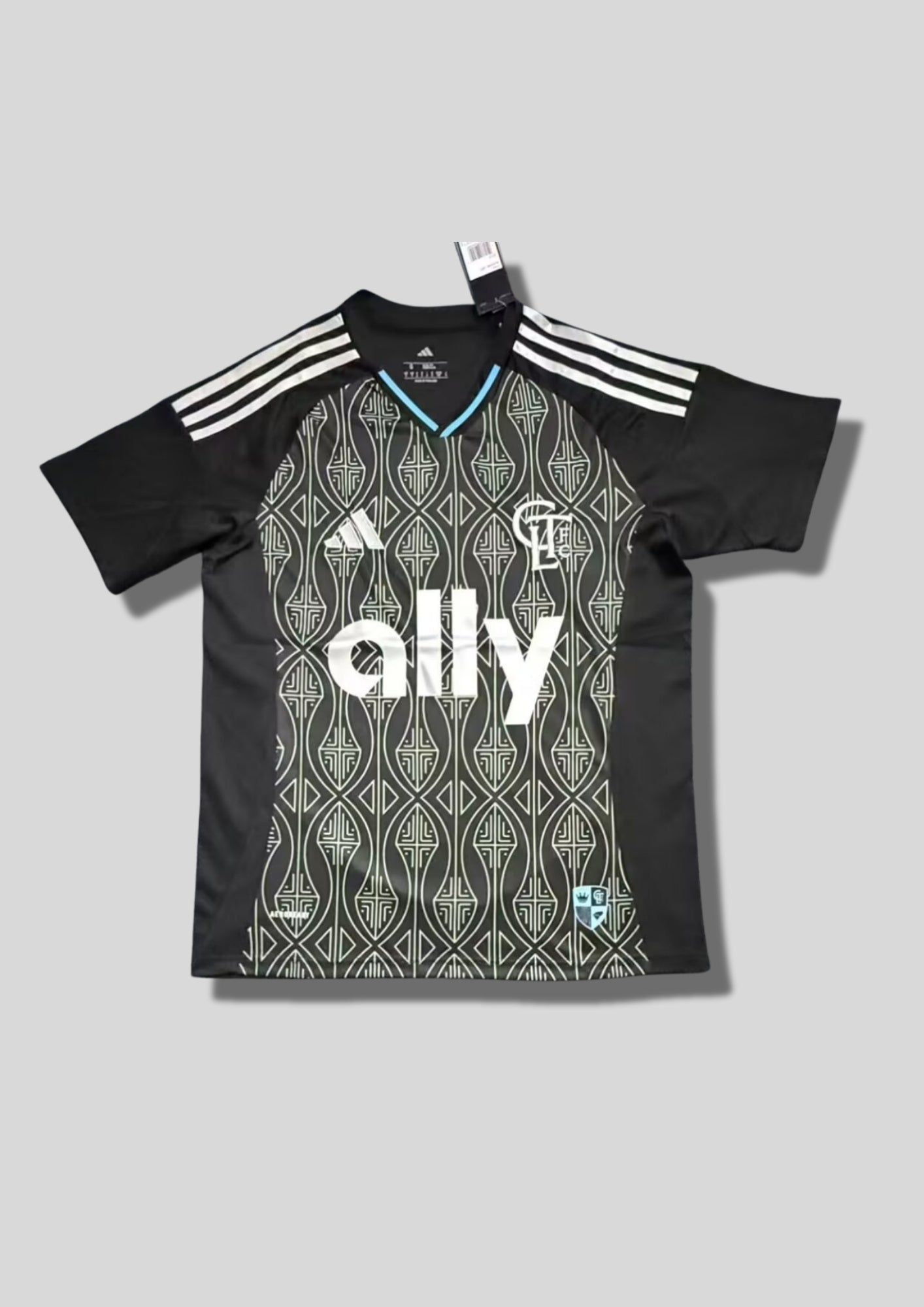 Charlotte FC Home 24/25 : Noir avec manches et panneaux latéraux unis et torse orné de motifs géométriques gris clair et sponsor "ally". GoalKits