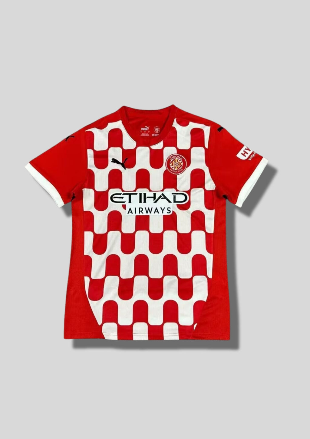 Girona FC Maillot Domicile 2024/25 : Un design audacieux qui remplace les rayures traditionnelles par un motif de vagues rouges et blanches entrelacées sur le torse. GoalKits