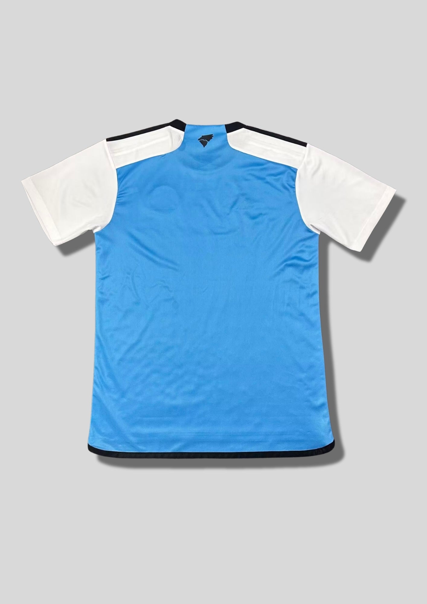 Charlotte FC Away 24/25 : Blanc avec un dégradé de vagues bleues sur le torse et sponsor "ally" GoalKits