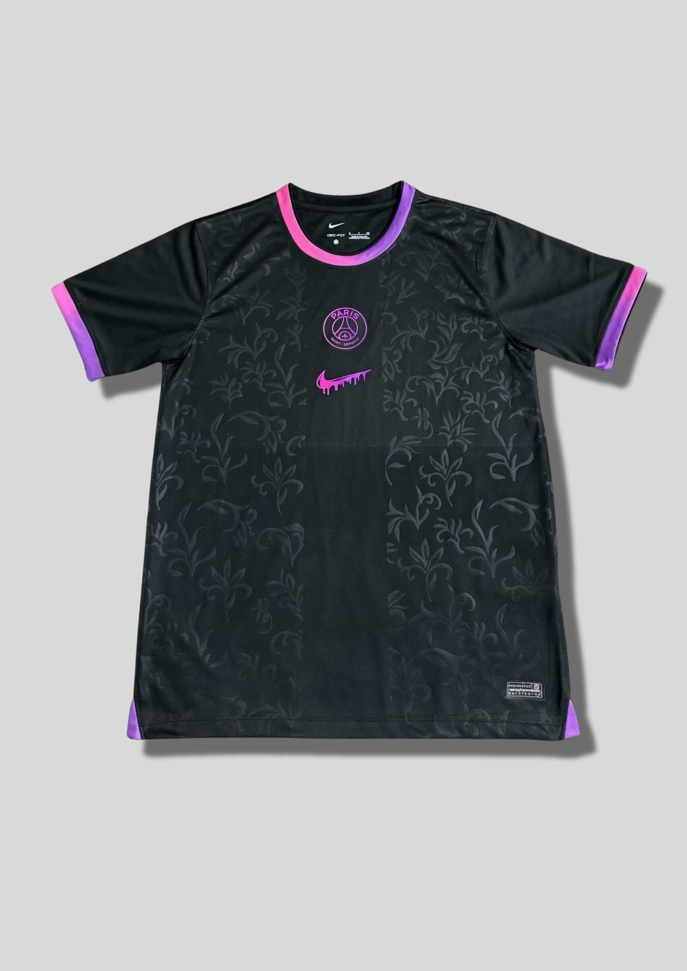 Paris Saint-Germain noir motif baroque : maillot noir orné d'un motif de volutes baroque texturé, avec logos centré et col/manches aux accents dégradés de rose et de violet. GoalKits