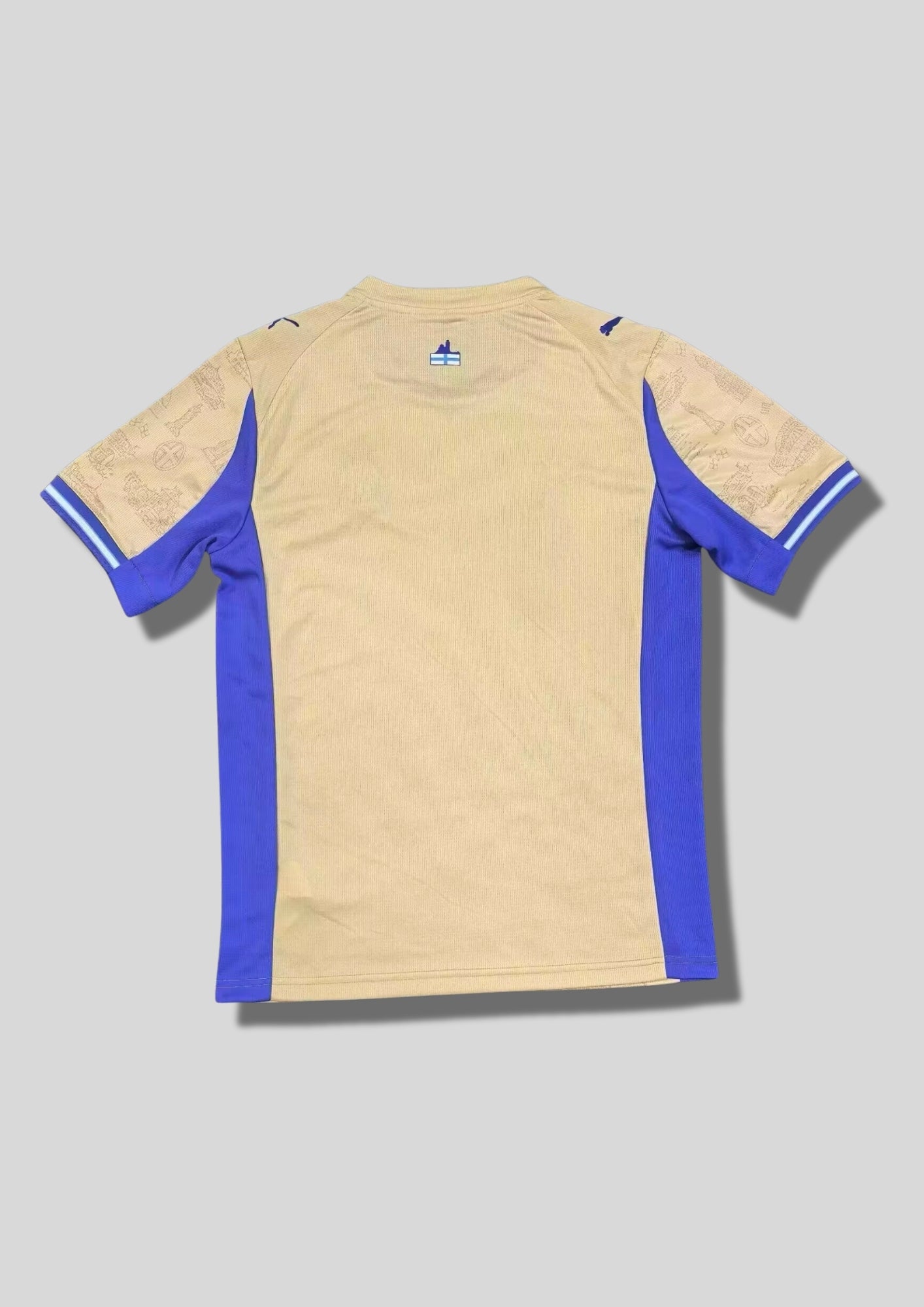 Olympique de Marseille "Third" 2024-2025 : maillot couleur sable/ocre orné de croquis de monuments marseillais, avec des panneaux latéraux, un col et des logos bleu roi. GoalKits