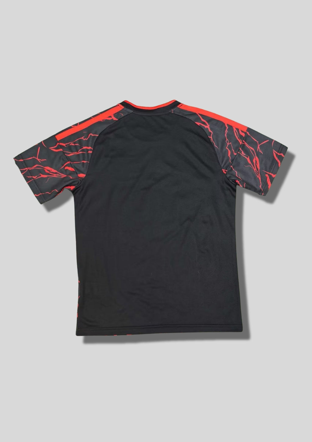 New York Red Bulls Pre-Match 24/25 : Noir avec des motifs d'éclairs rouges vifs sur tout le maillot et le logo Red Bull central. GoalKits