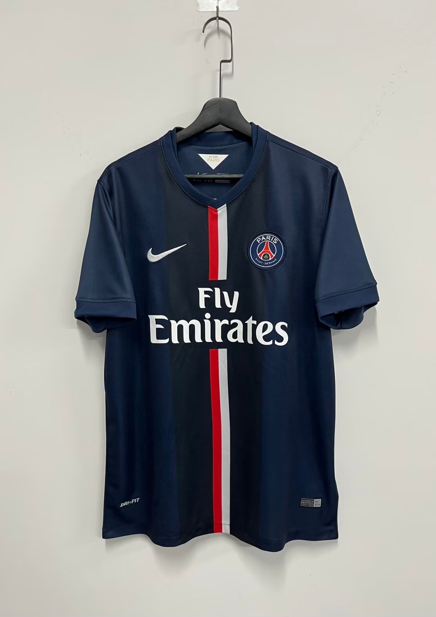Paris Saint-Germain domicile 2014-2015 : maillot bleu marine avec une large bande centrale verticale bicolore rouge et blanche, logos blancs et sponsor Fly Emirates. GoalKits