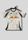 New York Red Bulls Away 24/25 : Crème avec des motifs graphiques grisés en pixels et détails noirs sur les flancs et les épaules. GoalKits
