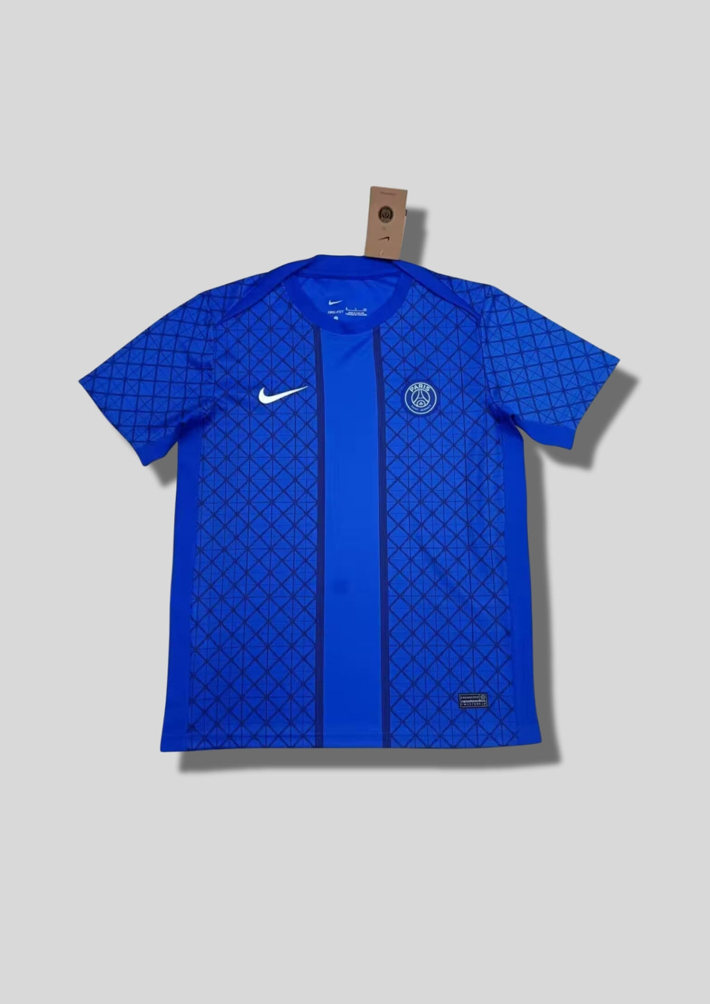 Paris Saint-Germain bleu roi à motifs géométriques : maillot bleu électrique avec un quadrillage de losanges sur tout le torse, une large bande centrale unie bordée de liserés foncés et logos blancs. GoalKits
