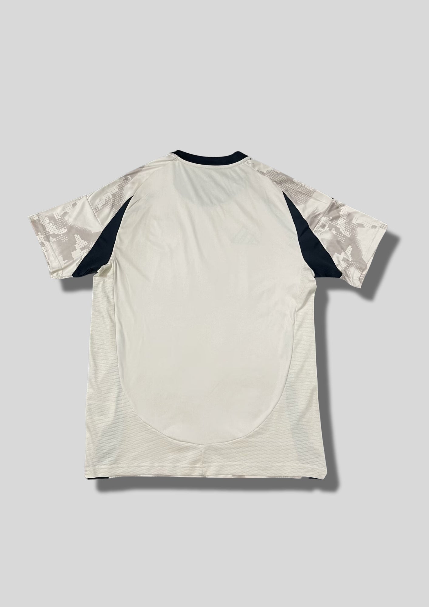 New York Red Bulls Away 24/25 : Crème avec des motifs graphiques grisés en pixels et détails noirs sur les flancs et les épaules. GoalKits
