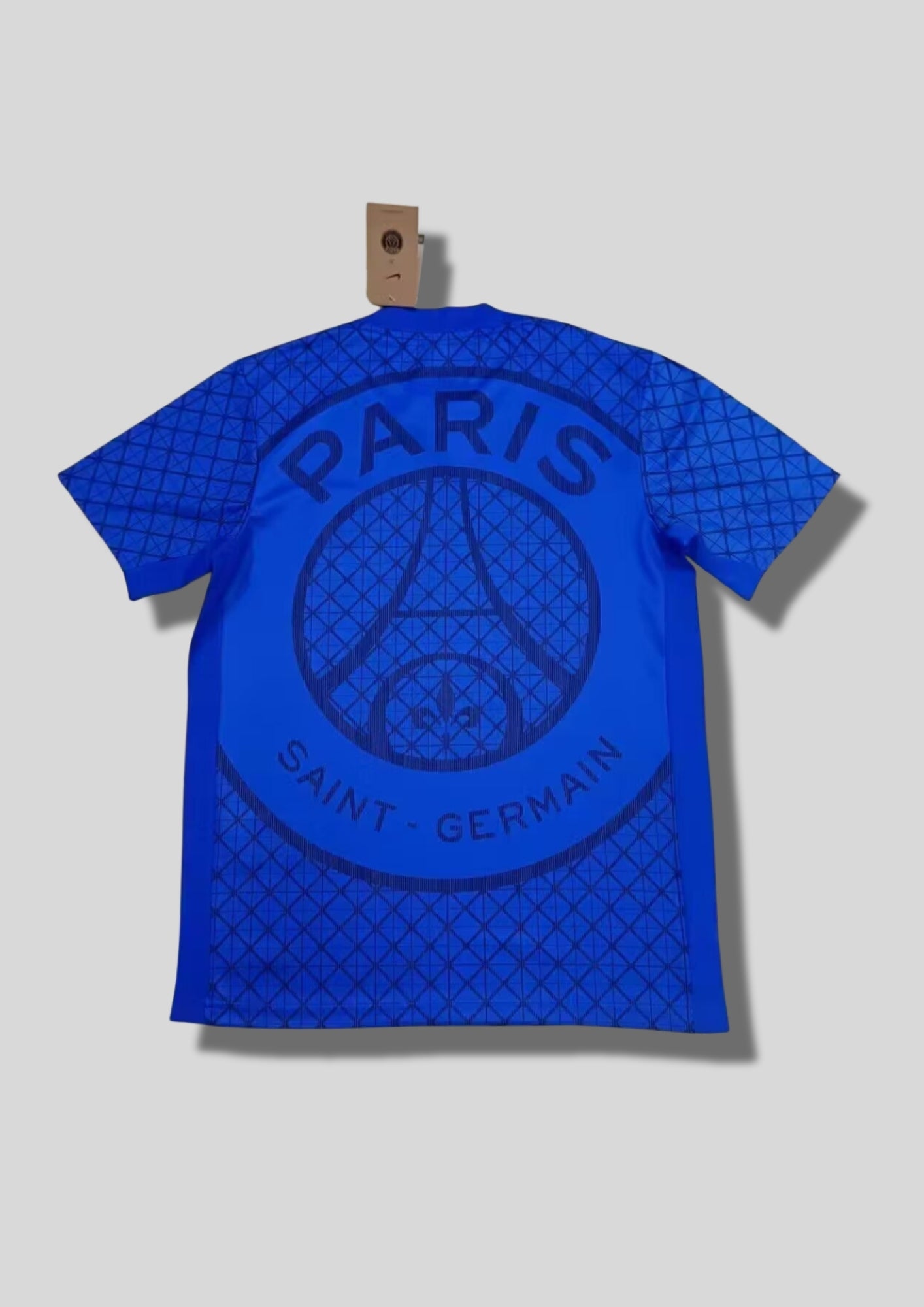 Paris Saint-Germain bleu roi à motifs géométriques : maillot bleu électrique avec un quadrillage de losanges sur tout le torse, une large bande centrale unie bordée de liserés foncés et logos blancs. GoalKits