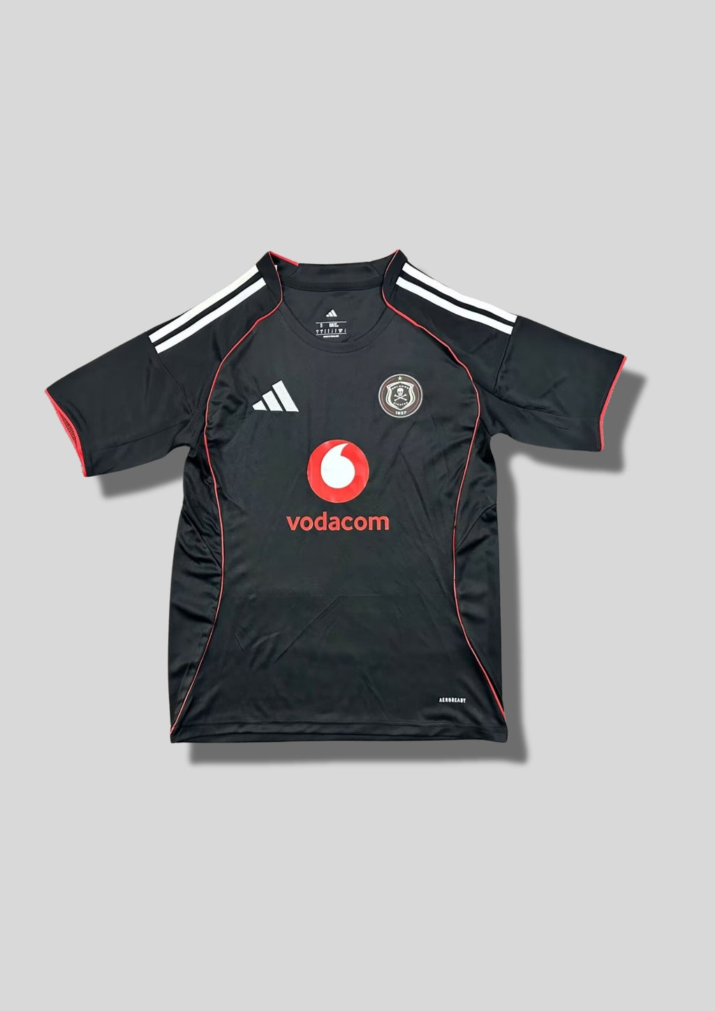 Orlando Pirates Home 24/25 : Noir avec de fines bordures rouges le long des panneaux latéraux et des manches, et le sponsor "vodacom" au centre. GoalKits