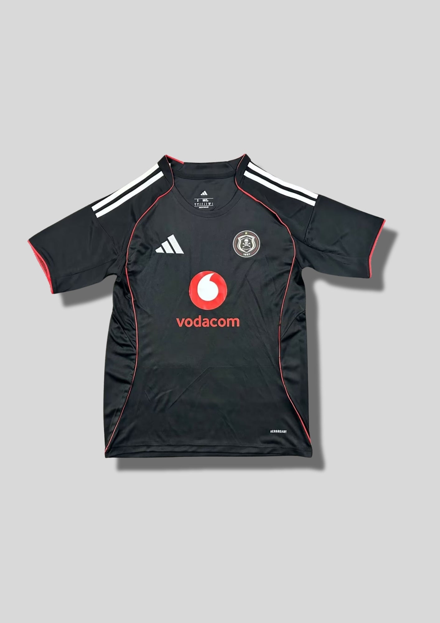 Orlando Pirates Home 24/25 : Noir avec de fines bordures rouges le long des panneaux latéraux et des manches, et le sponsor "vodacom" au centre. GoalKits