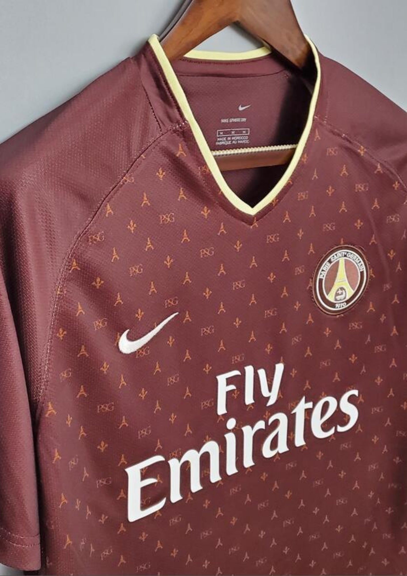 Paris Saint-Germain bordeaux monogramme : maillot couleur prune/bordeaux avec un motif monogramme "PSG" et Tour Eiffel sur tout le torse, col en V et liserés jaune pâle, sponsor Fly Emirates. GoalKits