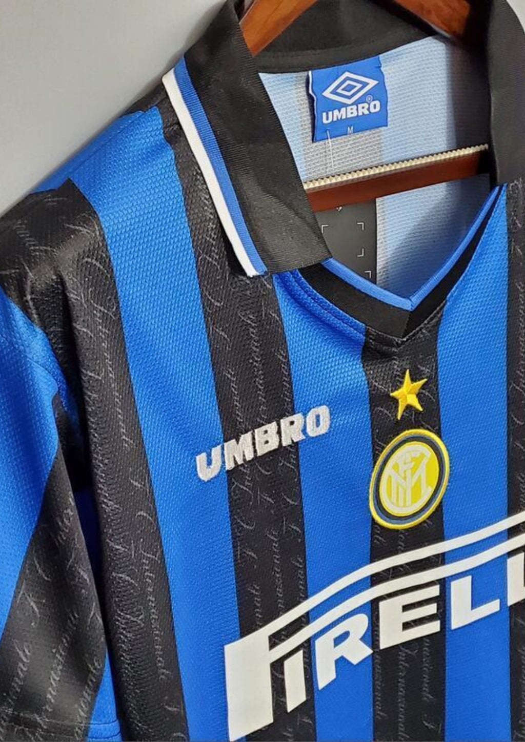 Inter Milan domicile 1997-1998 : maillot Umbro aux rayures verticales bleues et noires. Les bandes noires comportent le nom du club "F.C. Internazionale" en filigrane. GoalKits