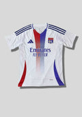 Olympique Lyonnais domicile 2024-2025 : maillot blanc avec deux bandes verticales centrales dégradées rouge et bleue, bandes Adidas bleu marine sur les épaules et sponsor Emirates. GoalKits