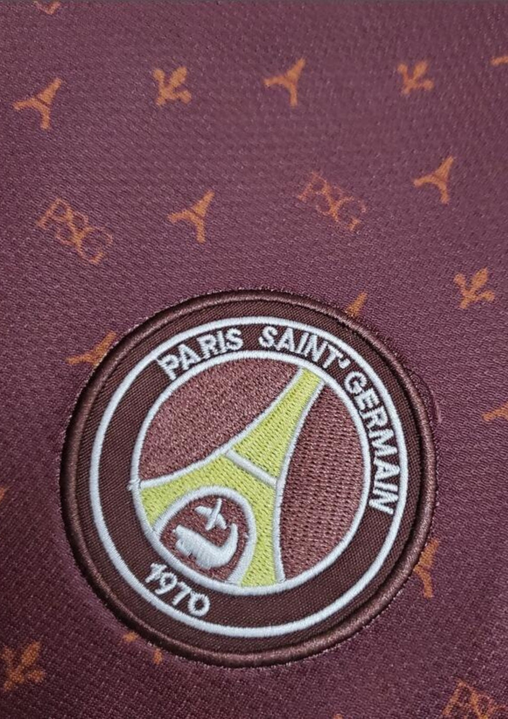 Paris Saint-Germain bordeaux monogramme : maillot couleur prune/bordeaux avec un motif monogramme "PSG" et Tour Eiffel sur tout le torse, col en V et liserés jaune pâle, sponsor Fly Emirates. GoalKits