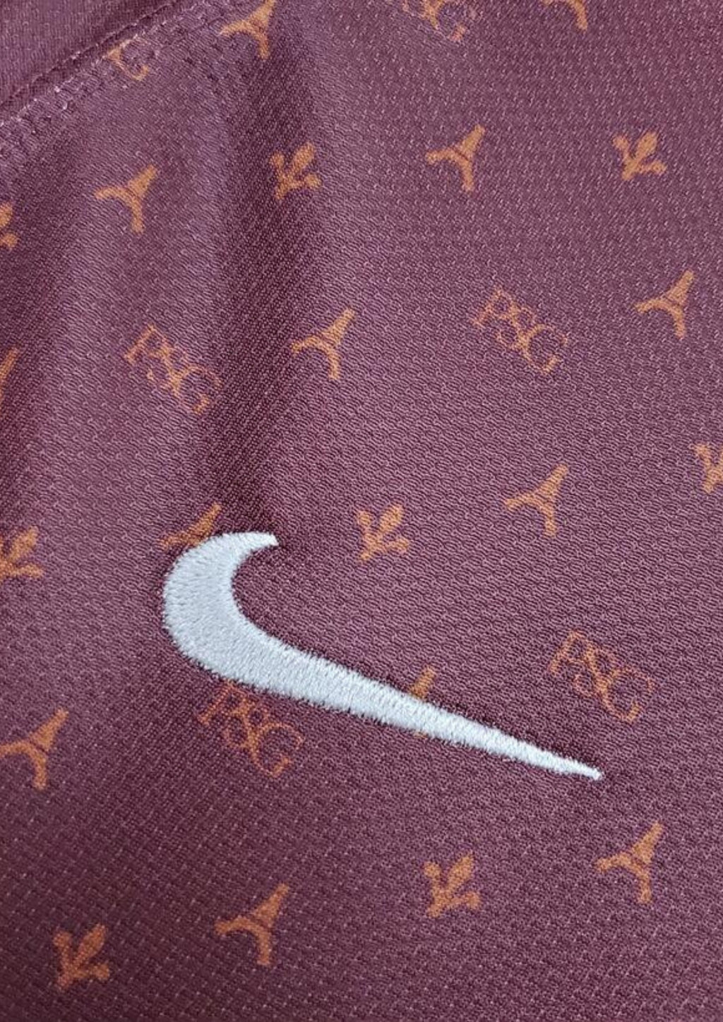 Paris Saint-Germain bordeaux monogramme : maillot couleur prune/bordeaux avec un motif monogramme "PSG" et Tour Eiffel sur tout le torse, col en V et liserés jaune pâle, sponsor Fly Emirates. GoalKits
