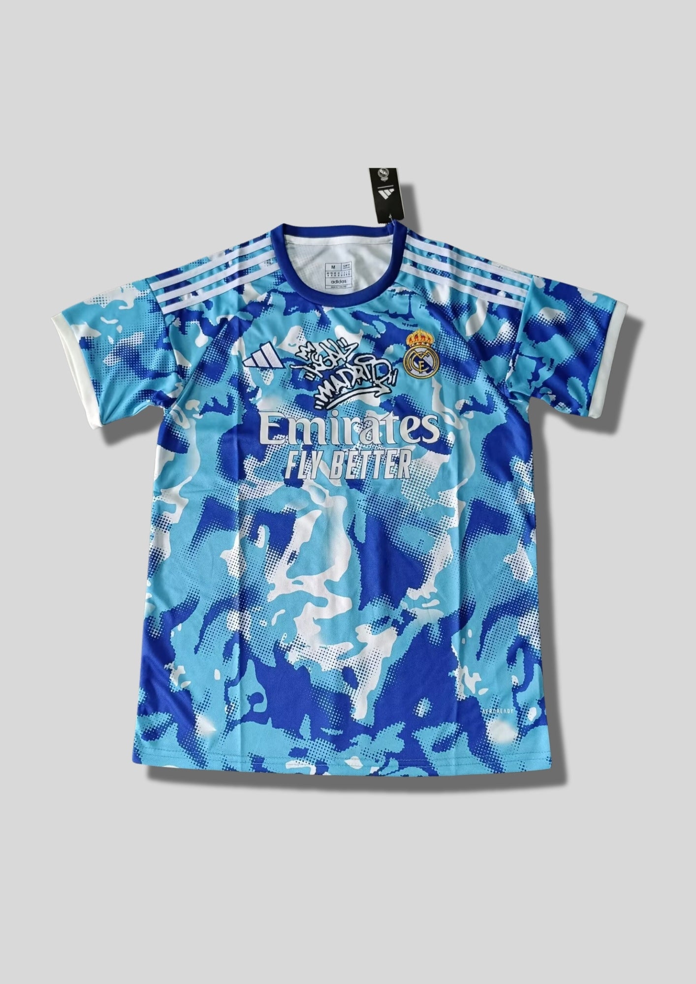 Maillot d'entraînement / Édition Spéciale – Camouflage bleu et blanc avec logo "Real Madrid" style graffiti sur la poitrine. GoalKits