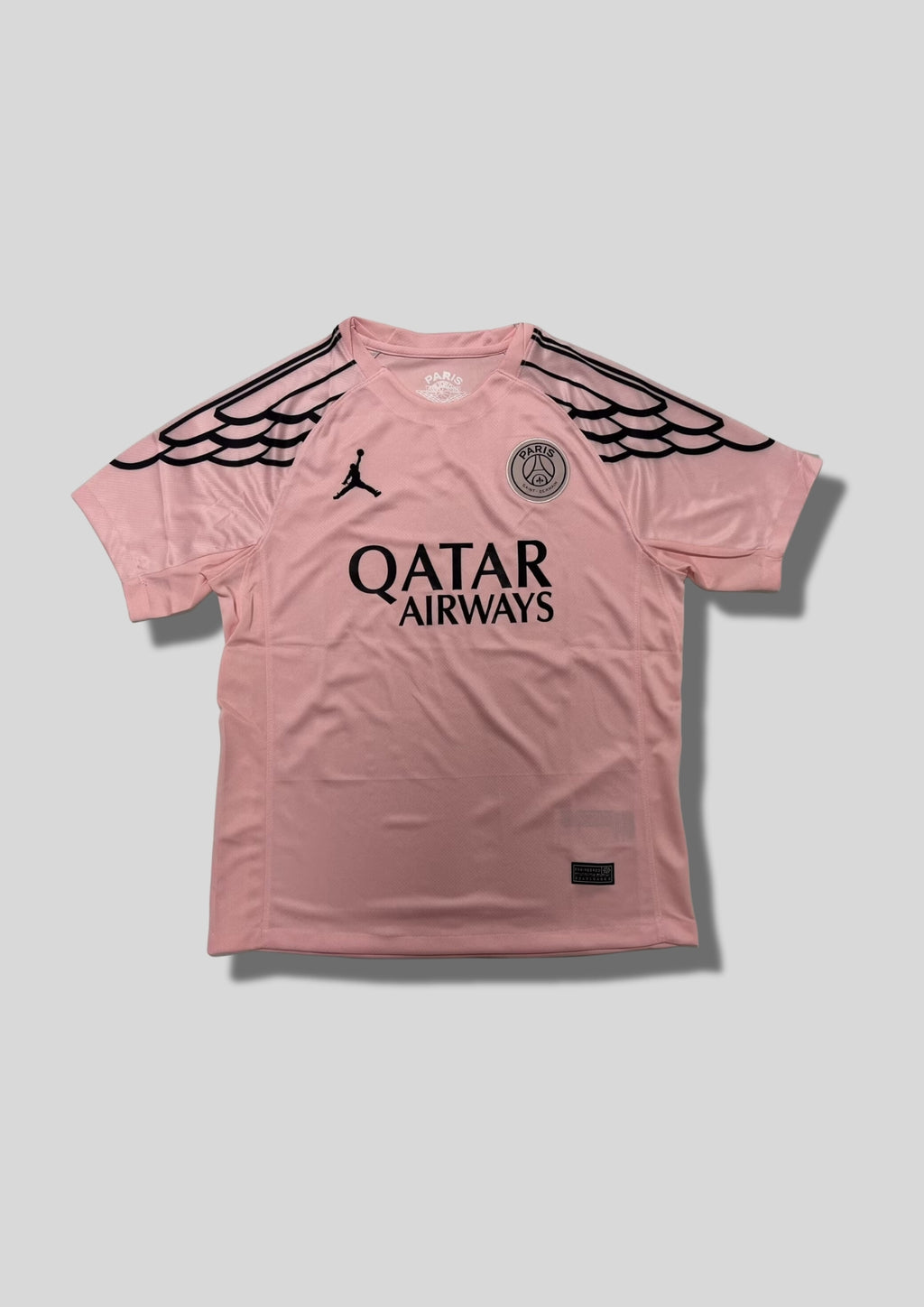 Paris Saint-Germain Jordan rose & "ailes" noires : maillot rose clair avec des motifs d'ailes stylisés noirs sur les manches, logo Jordan et sponsor Qatar Airways noirs. GoalKits