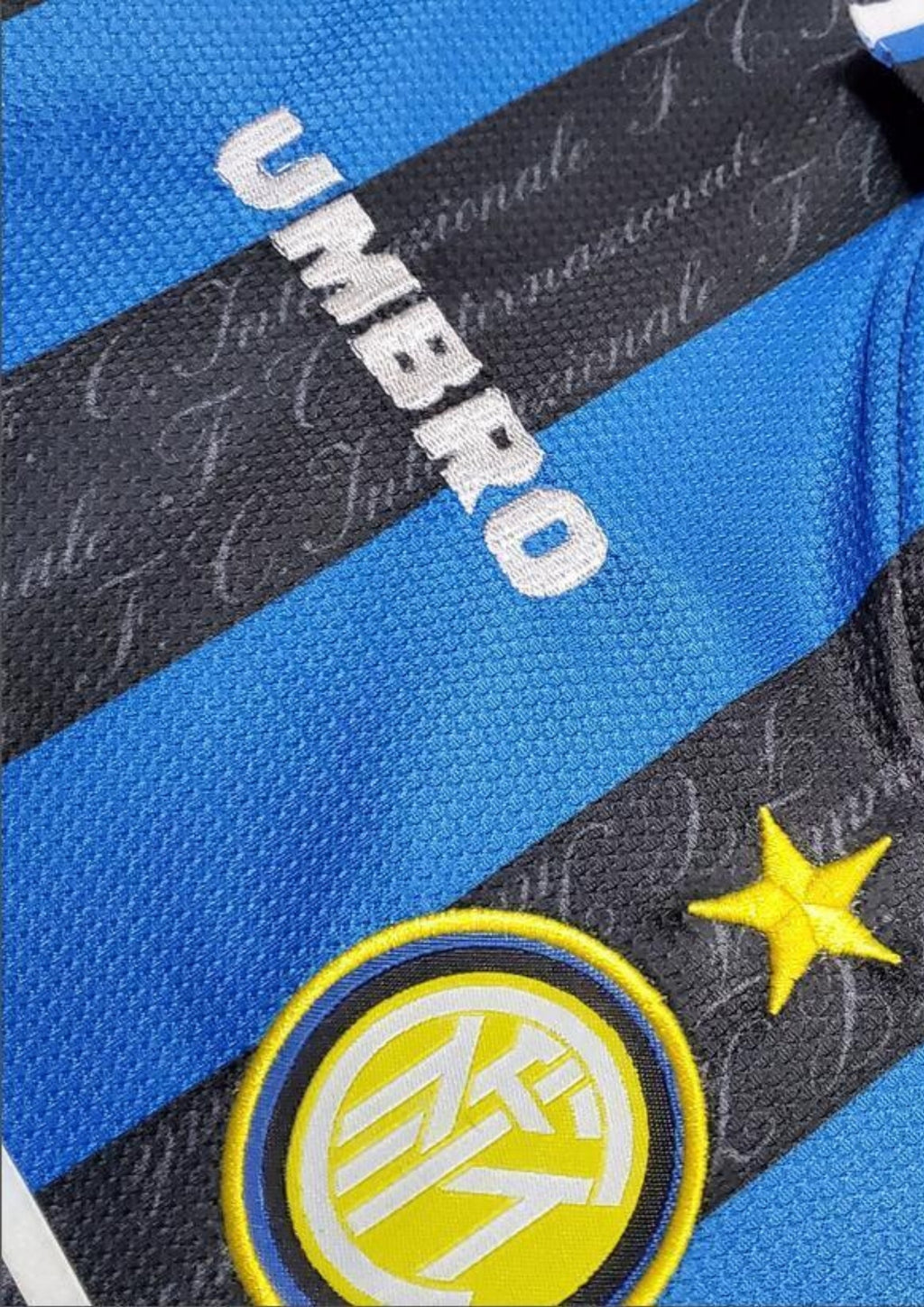 Inter Milan domicile 1997-1998 : maillot Umbro aux rayures verticales bleues et noires. Les bandes noires comportent le nom du club "F.C. Internazionale" en filigrane. GoalKits