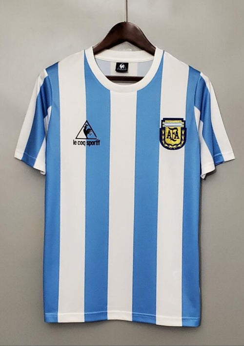 Argentine 1986 (Domicile) Rayures verticales ciel et blanc, logo Le Coq Sportif noir, écusson AFA classique brodé. GoalKits