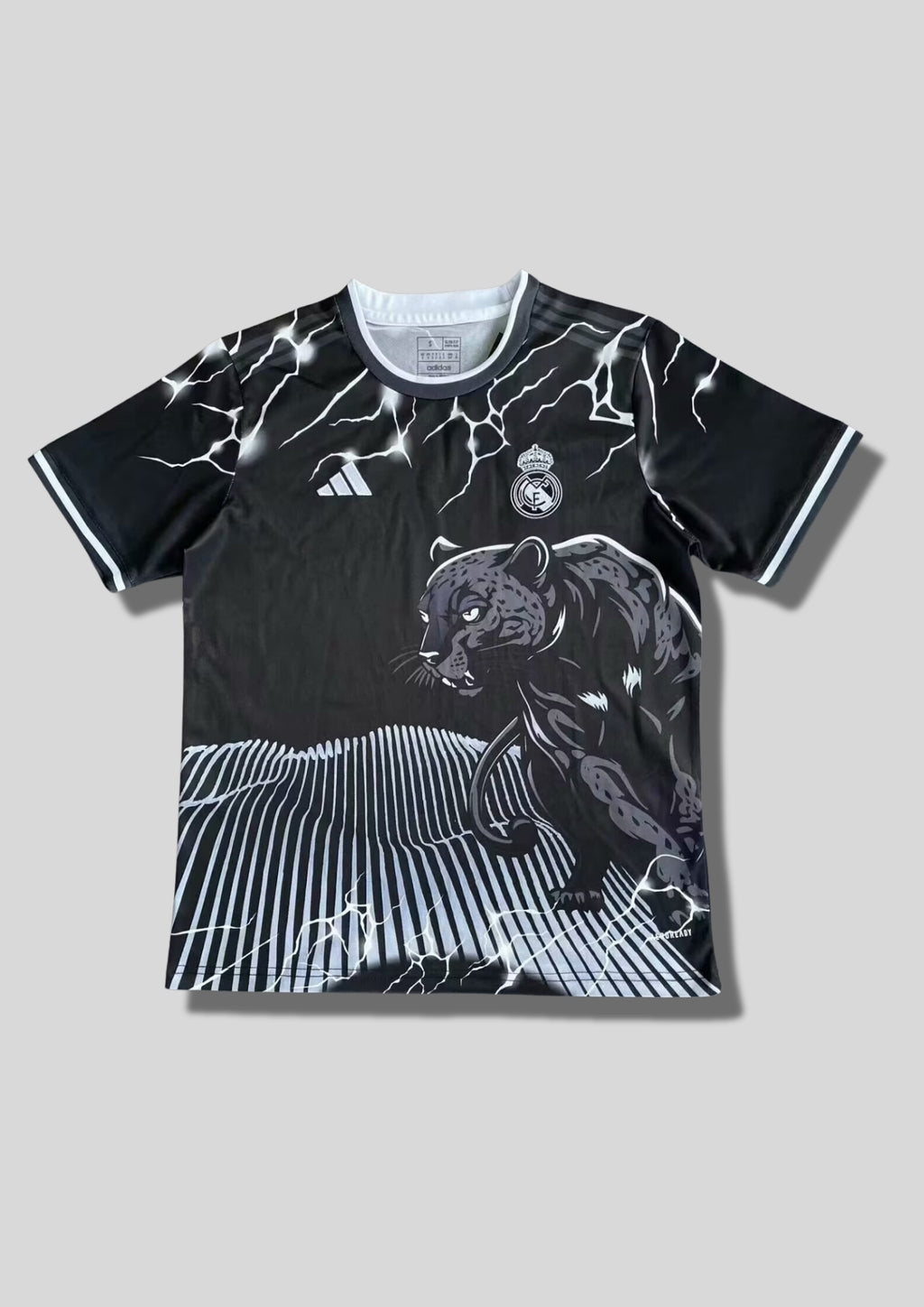 Real Madrid : Maillot d'entraînement / Édition Spéciale – Noir avec graphisme Panthère, éclairs et rayures verticales blanches au bas. GoalKits