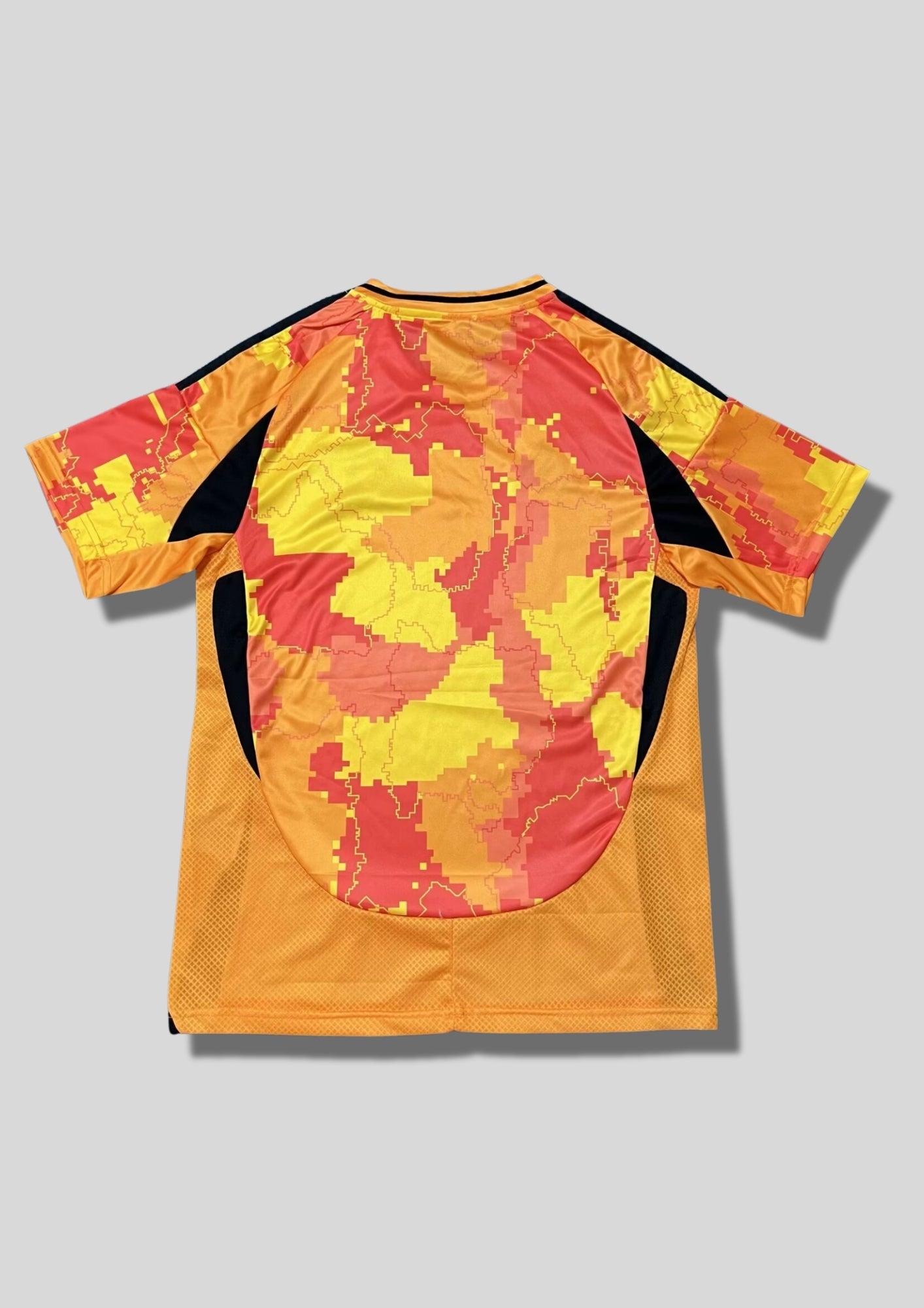 Paris FC "Third" 2024-2025 : maillot Adidas aux couleurs vives (orange, jaune et rouge) avec un motif camouflage pixelisé représentant les arrondissements de Paris, logos noirs et sponsor Bahrain Victorious. GoalKits