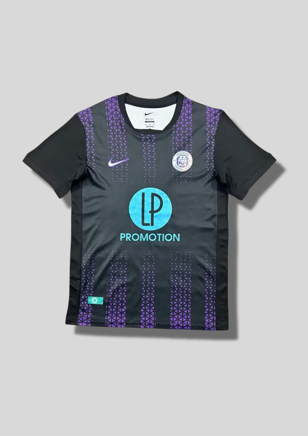 Toulouse FC extérieur 2024-2025 : maillot noir Nike avec des bandes verticales violettes composées de petits motifs géométriques, manches noires unies et sponsor LP Promotion en bleu turquoise. GoalKits