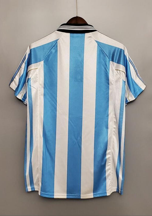 rgentine 1998 (Domicile) Rayures ciel et blanc, col noir en V, logo Adidas central, blason AFA avec lauriers dorés. GoalKits