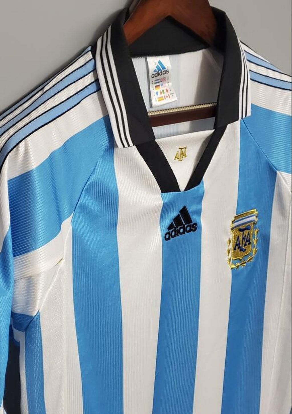 rgentine 1998 (Domicile) Rayures ciel et blanc, col noir en V, logo Adidas central, blason AFA avec lauriers dorés. GoalKits