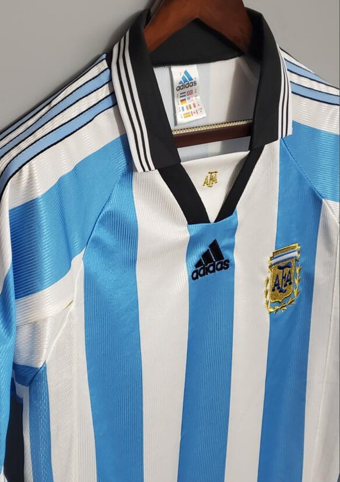rgentine 1998 (Domicile) Rayures ciel et blanc, col noir en V, logo Adidas central, blason AFA avec lauriers dorés. GoalKits