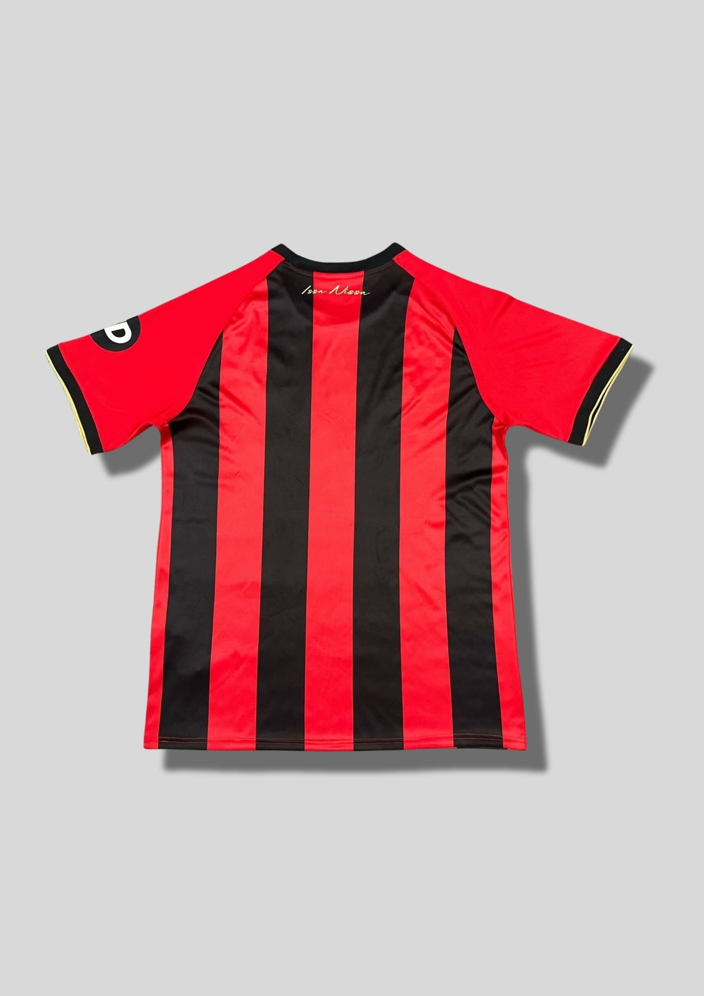 OGC Nice domicile 2024-2025 (120 ans) : maillot Le Coq Sportif aux rayures verticales rouges et noires traditionnelles, avec des logos et le sponsor INEOS dorés pour célébrer l'anniversaire du club. GoalKits