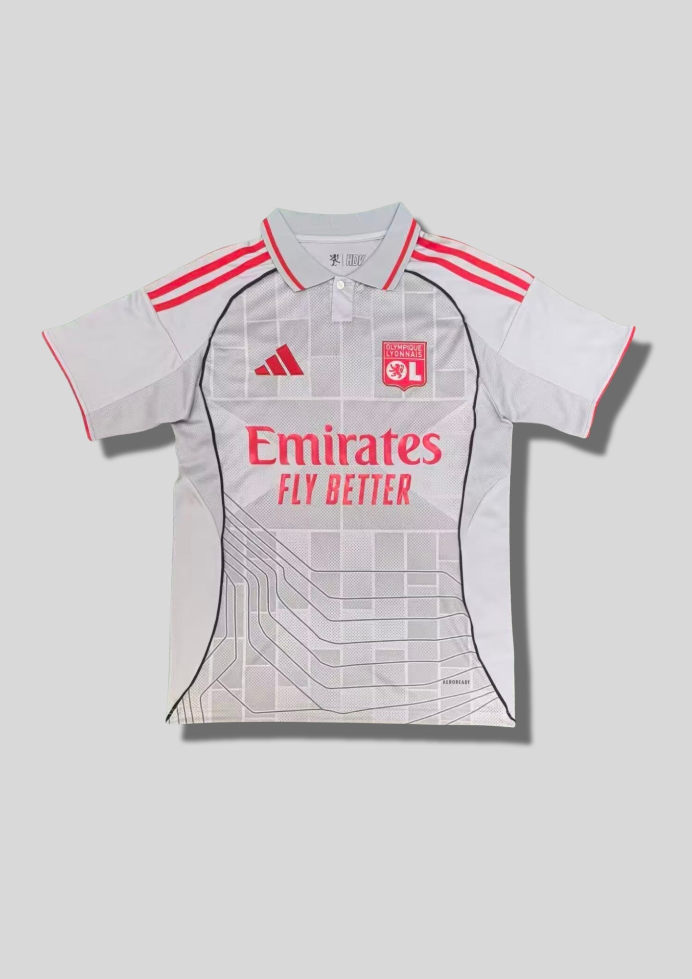 Olympique Lyonnais "Third" 2024-2025 : maillot gris clair avec un col polo, des motifs géométriques et des lignes rappelant des circuits imprimés, logos et détails rose vif. GoalKits