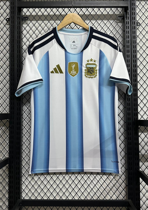 Argentine 2024 (Domicile) Rayures ciel (dégradées) et blanc, détails dorés, badge FIFA World Champions 2022. GoalKits