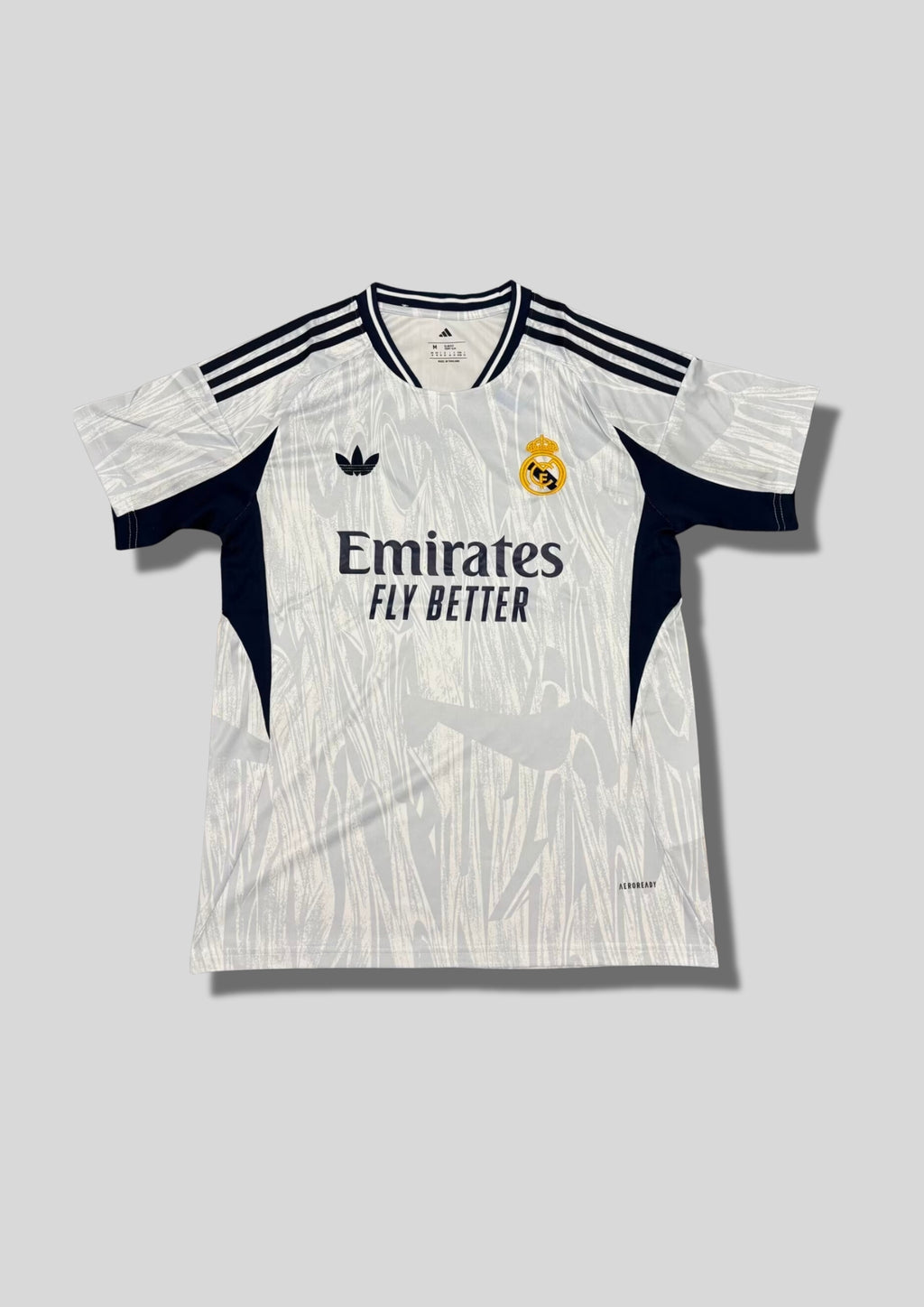Real Madrid : Maillot d'entraînement / Édition Spéciale – Blanc avec motifs texturés gris "coup de pinceau" et détails bleu marine. GoalKits