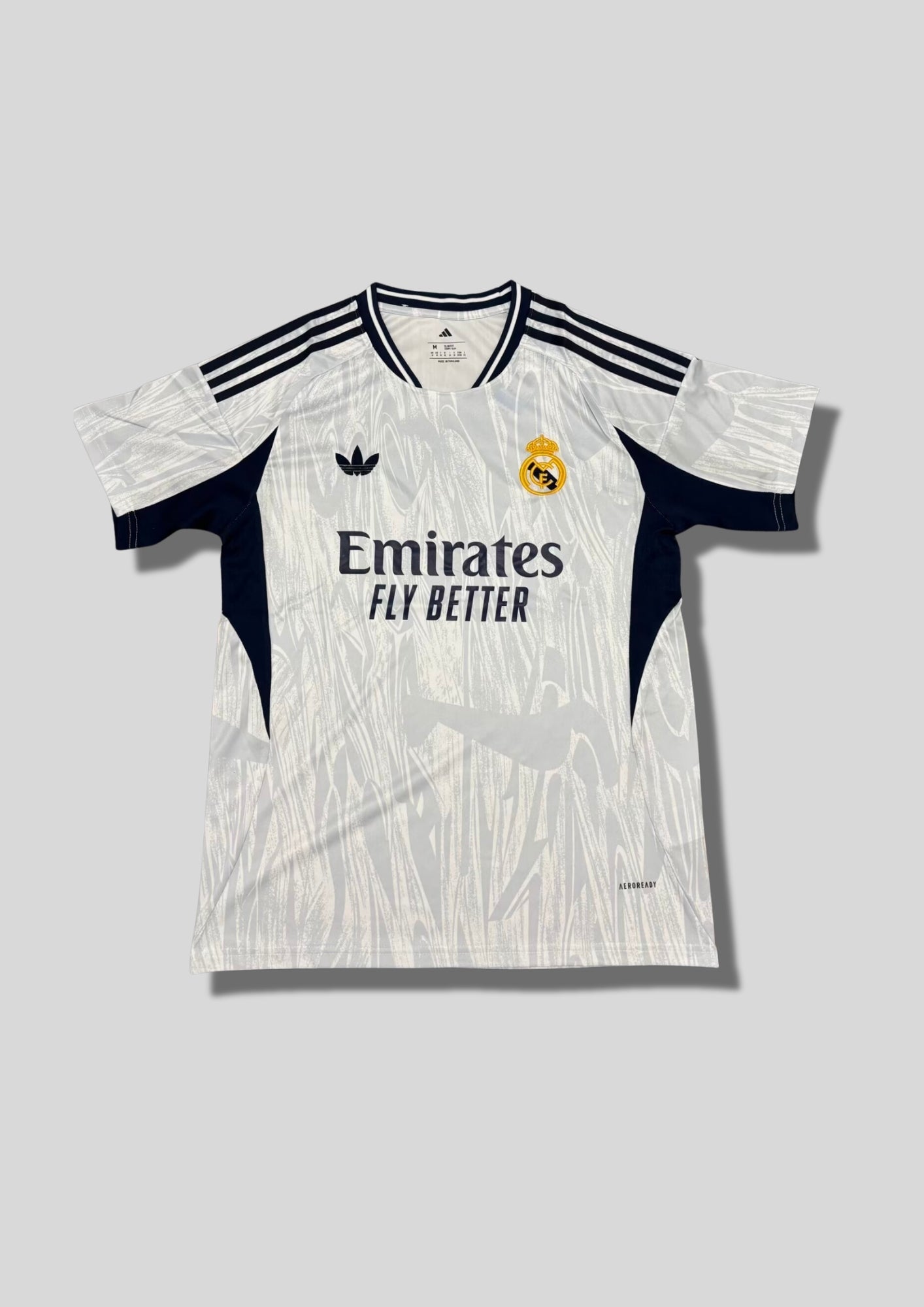 Real Madrid : Maillot d'entraînement / Édition Spéciale – Blanc avec motifs texturés gris "coup de pinceau" et détails bleu marine. GoalKits