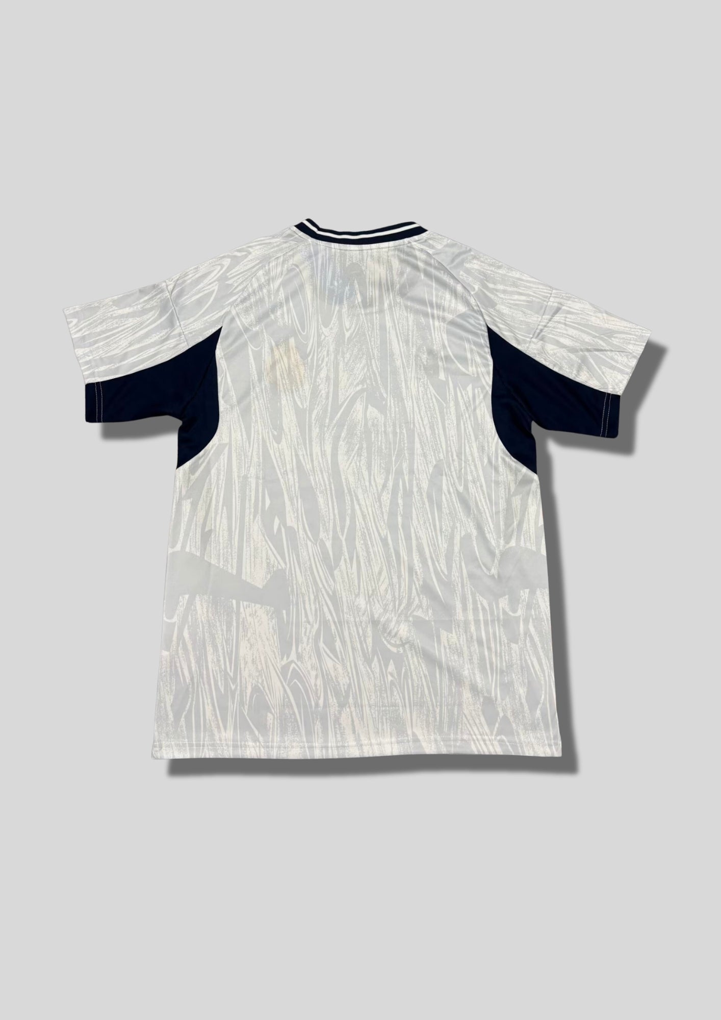 Real Madrid : Maillot d'entraînement / Édition Spéciale – Blanc avec motifs texturés gris "coup de pinceau" et détails bleu marine. GoalKits