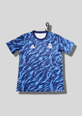 Real Madrid : Maillot d'entraînement / Édition Spéciale – Motif intégral de flammes bleues (style vagues/eau) sur fond bleu marine, sans sponsor central. GoalKits