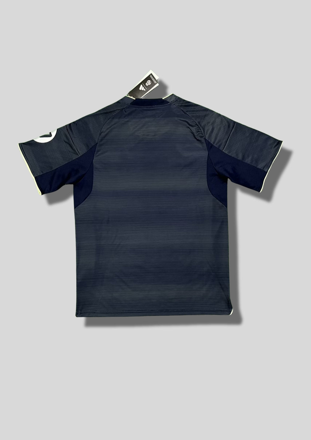 Real Madrid : Maillot d'entraînement / Édition Spéciale – Gris anthracite avec de fines rayures horizontales, détails jaune fluo (volt) et logo HP sur la manche. GoalKits
