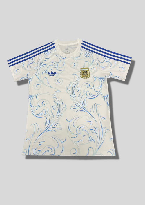 Argentine 2024 (Lifestyle/Retro) Blanc, motifs floraux baroques bleus, logo Adidas Trefoil et écusson AFA classique. GoalKits