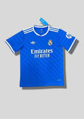 Real Madrid : Maillot d'entraînement / Édition Spéciale – Bleu roi avec fines rayures diagonales ton sur ton, col et bords de manches blancs, et logo HP sur la manche. GoalKits